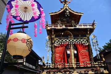 日本の岐阜県の高山市　世界遺産の高山祭　屋台と呼ばれる山車とからくり人形　快晴の青空と美しい和傘