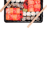 Big sushi set ib black plastic box on white background, top view close up, copy space