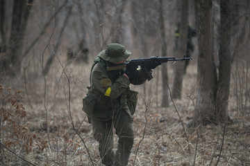 Fototapeta premium Active military exercises in the forest. Shootout army in the autumn forest. Training airsoft teams in Russia.
