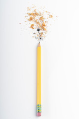 recently sharpened pencil with wood shavings and mine on a white table