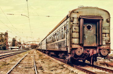 Abandoned rusty passenger railway carriage on a rails.