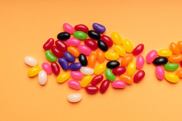 colourful jelly beans candies orange background Top view