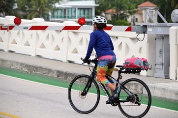 Woman bicyclist waiting for a drawbridge to open for traffic