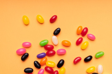 colourful jelly beans candies orange background Top view