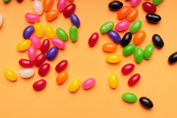 colourful jelly beans candies orange background Top view