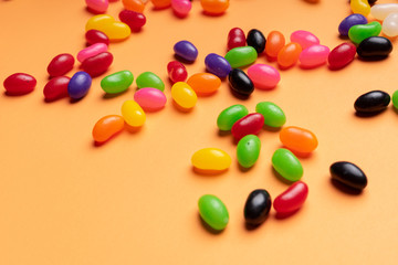 colourful jelly beans candies orange background Top view