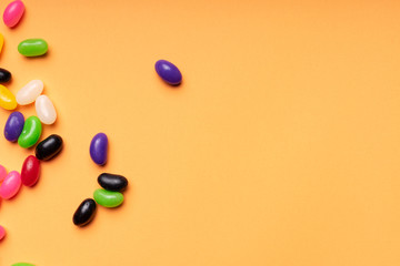 colourful jelly beans candies orange background Top view