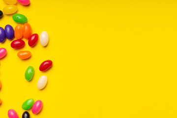 colourful jelly beans candies yellow background Top view 