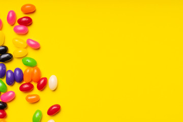 Obraz premium colourful jelly beans candies yellow background Top view 