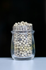 Pepper in a jar on black background.