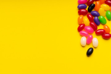 Obraz premium colourful jelly beans candies yellow background Top view 