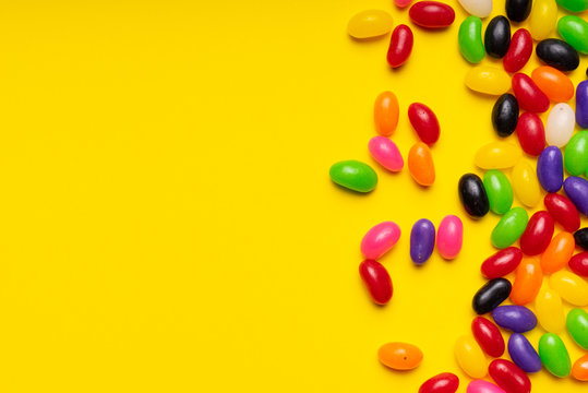 colourful jelly beans candies yellow background Top view 