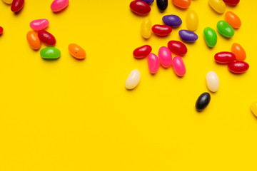 colourful jelly beans candies yellow background Top view 