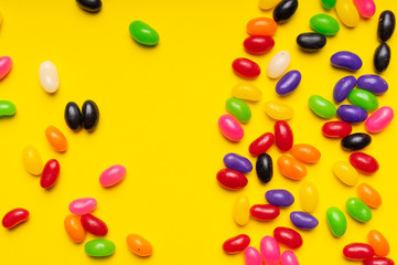 colourful jelly beans candies yellow background Top view 