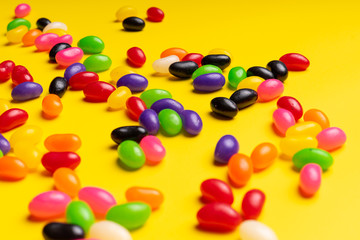 colourful jelly beans candies yellow background Top view 