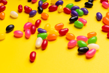 colourful jelly beans candies yellow background Top view 