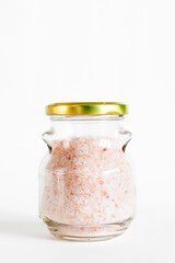 Himalayan pink salt in bottle on background