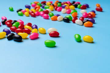 Fototapeta na wymiar colourful jelly beans candies blue background Top view