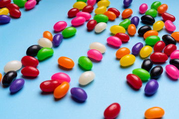 colourful jelly beans candies blue background Top view