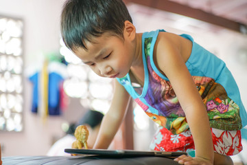Asian boy playing tablet computer connet to internet browser