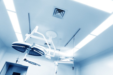 Working surgeon on the background of surgical lamp.