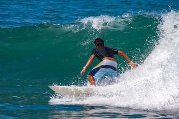 Ecuador. Beach near the village of Montanita. Surfer performs a trick. Surfer training. Athlete on the longboard. The Village Of Montanita. The waves of the Pacific ocean.