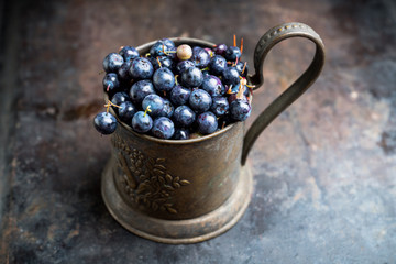 Freshly harvested blueberries in metal cup. Selective focus. Shallow depth of field.
