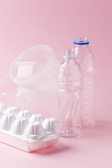 Group of transparent plastic containers box of food package on pink background. Concept of earth...