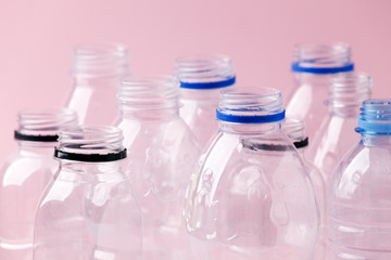Set of empty plastic water bottles on pink background, chemical industry, eco recycle plastic...