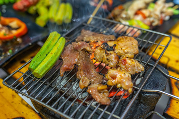 Closeup photo of grilled meat and vegetables on charcoal stove