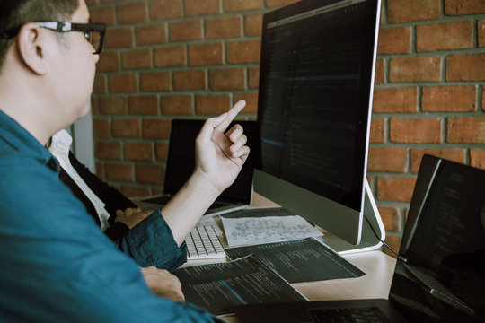 Developing programming and coding technologies working in a software engineers developing applications together in office.