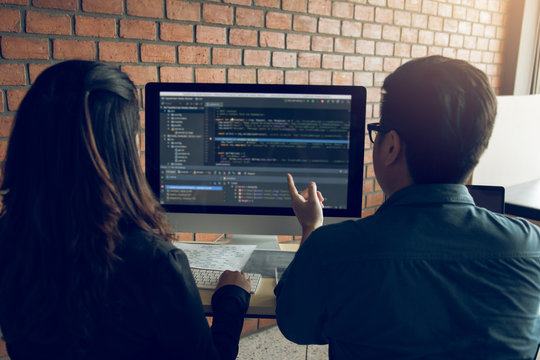 Developing programming and coding technologies working in a software engineers developing applications together in office.