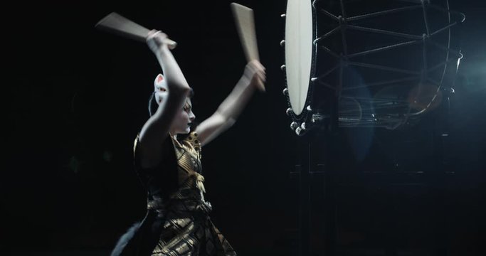 Female japanese drummer in traditional kitsune clothing playing on taiko drums, isolated on black background, - culture, tradition concept 4k footage