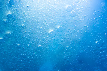 Air bubbles in the water background.Abstract oxygen bubbles in the sea.Circle foamy air in the ocean.Water bubbles isolate on blue background.