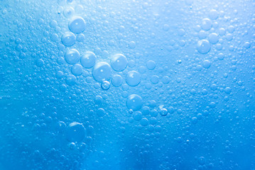 Air bubbles in the water background.Abstract oxygen bubbles in the sea.Circle foamy air in the ocean.Water bubbles isolate on blue background.