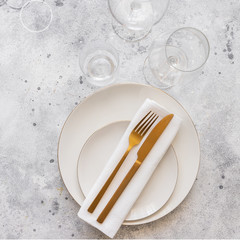Gold cutlery knife and fork , wine glasses on the stone background for restaurant dinner concept.