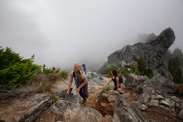 Adventurous Girl is hiking up a steep trail up a beautiful rocky mountain during a cloudy summer morning. Taken on Crown Mountain, North Vancouver, BC, Canada. © edb3_16