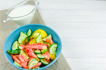 summer salad with cucumbers and tomatoes on white background
