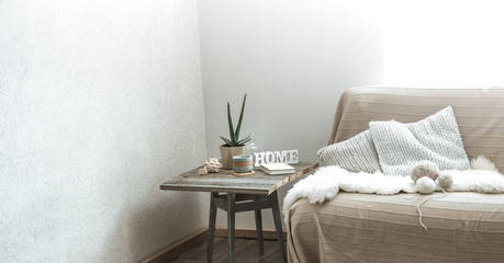 Home sofa with objects of cozy decor in the living room