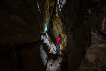 Adventurous girl is exploring the inside of a natural cave in Skaha Bluffs Provincial Park,...