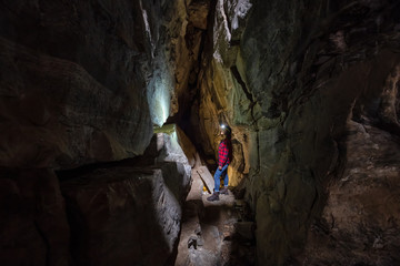 Adventurous girl is exploring the inside of a natural cave in Skaha Bluffs Provincial Park,...