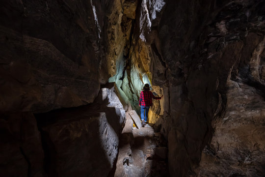 Adventurous girl is exploring the inside of a natural cave in Skaha Bluffs Provincial Park, Penticton, British Columbia, Canada.