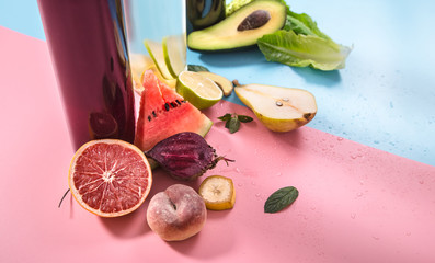 Glass bottles with natural drinks on a colored background