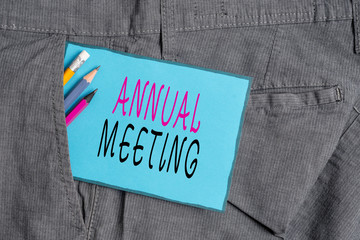 Conceptual hand writing showing Annual Meeting. Concept meaning yearly meeting of the general membership of an organization Writing equipment and blue note paper in pocket of trousers