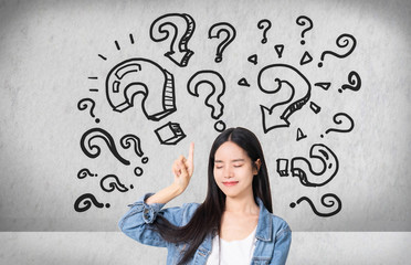 Question Marks with young woman in a thoughtful pose.Asianl woman with questioning expression and...