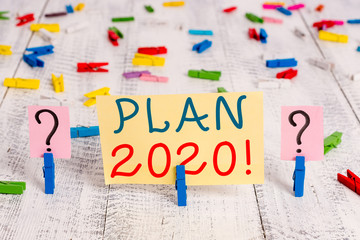 Writing note showing Plan 2020. Business concept for detailed proposal doing achieving something next year Crumbling sheet with paper clips placed on the wooden table