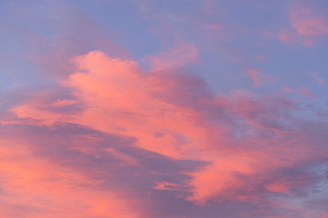 Naklejka na ściany i meble Pink colorful clouds on a blue sky.