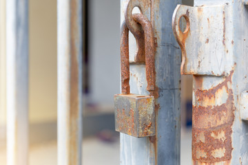 Selective focus of Old master key with rust unlocked on old aluminum fence, Security concepts