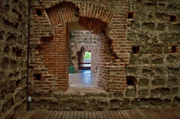 Viejo túnel de piedra con ventanas luz del sol en el castillo