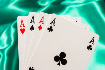 The combination of playing cards poker casino. Four aces on green background
